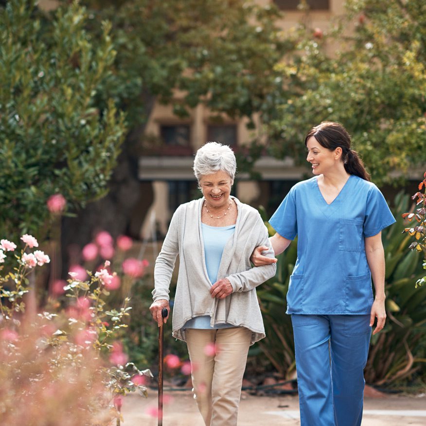 Caregiver-walking-with-a-senior-patient-outdoors
