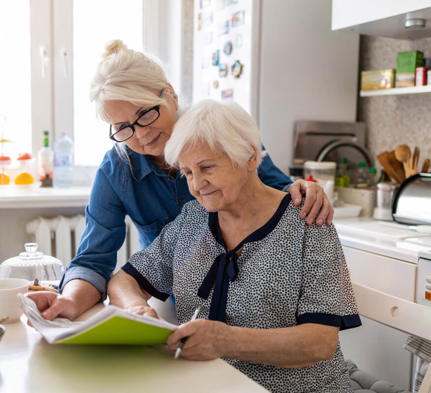 Female-assisted-living-worker-helping-senior-woman-with-paperwork