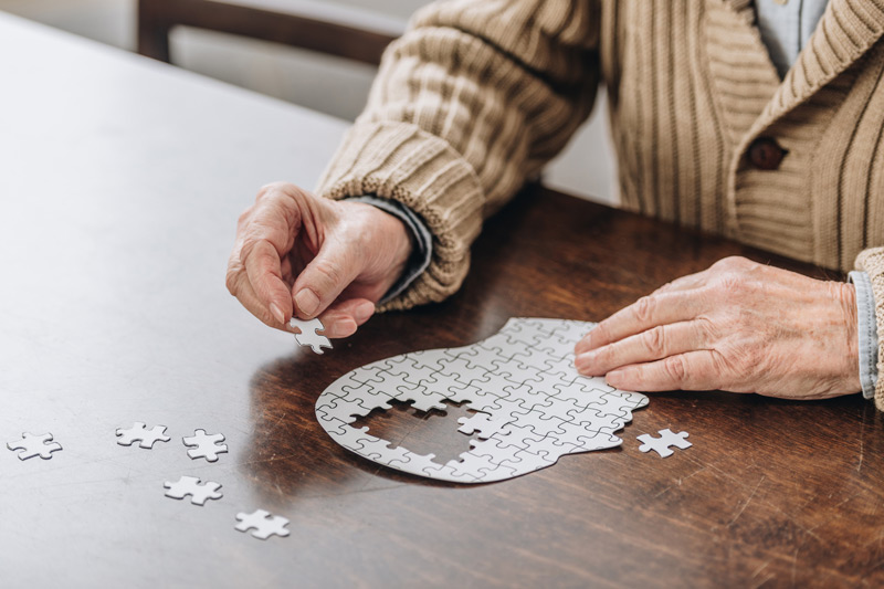 Senior-man-working-on-puzzle-at-facility-offering-memory-care-in-Camarillo Senior-man-working-on-puzzle-at-facility-offering-memory-care-in-Camarillo