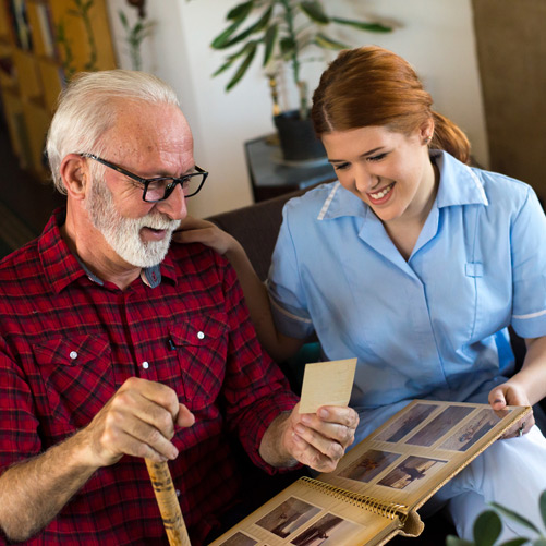 Senior-showing-pictures-to-female-nurse-at-facility-offering-memory-care-in-Ventura-County Senior-showing-pictures-to-female-nurse-at-facility-offering-memory-care-in-Ventura-County