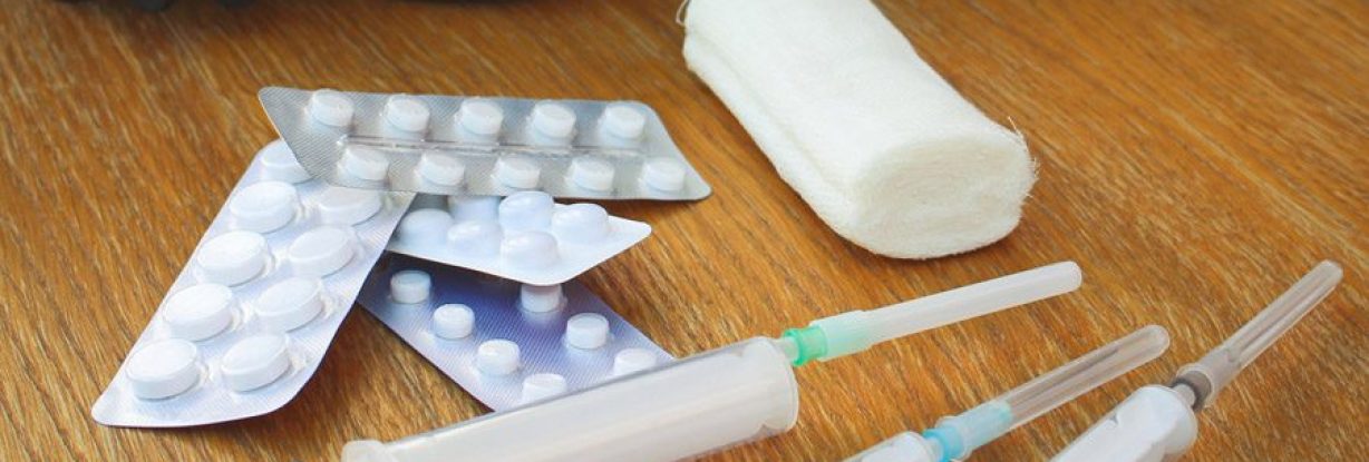 Open-suitcase-with-medication-and-syringes-lying-on-the-floor